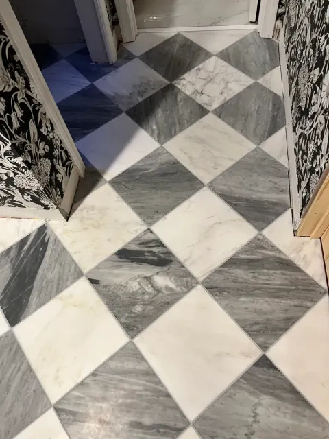 White and gray marble-veined tile laid on the diagonal in a checkerboard