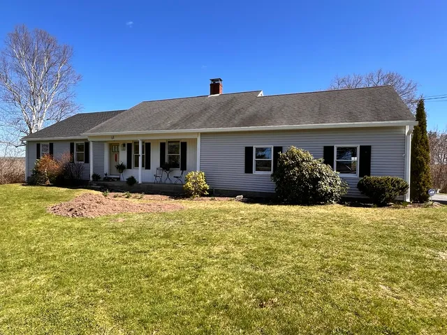 Ranch home with new white gutters under a clear blue sky