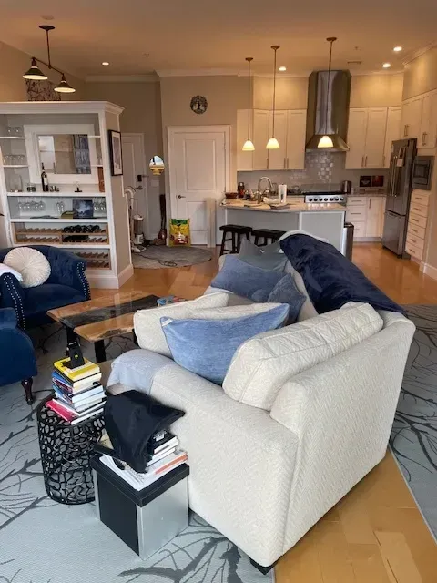 A living room with a white couch and blue chairs