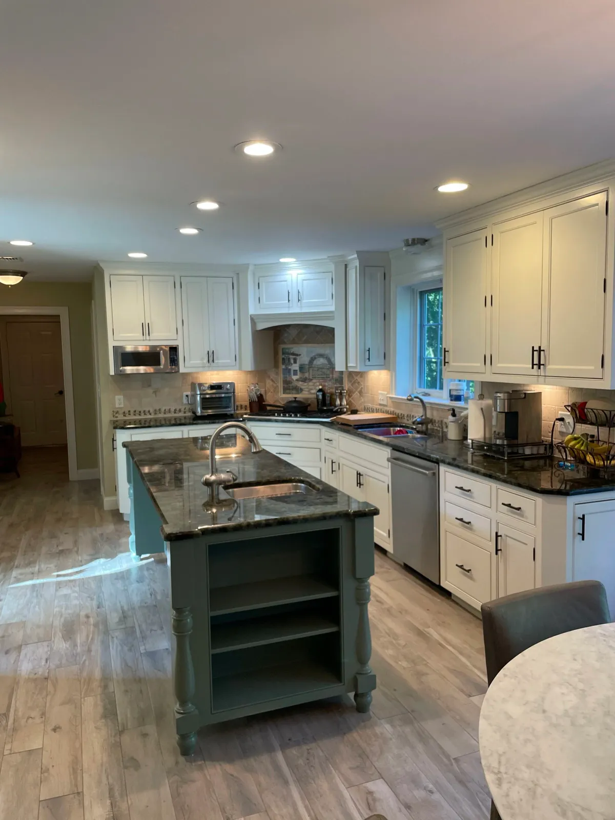 A painted kitchen with white shelves and a green accent island in Foxboro