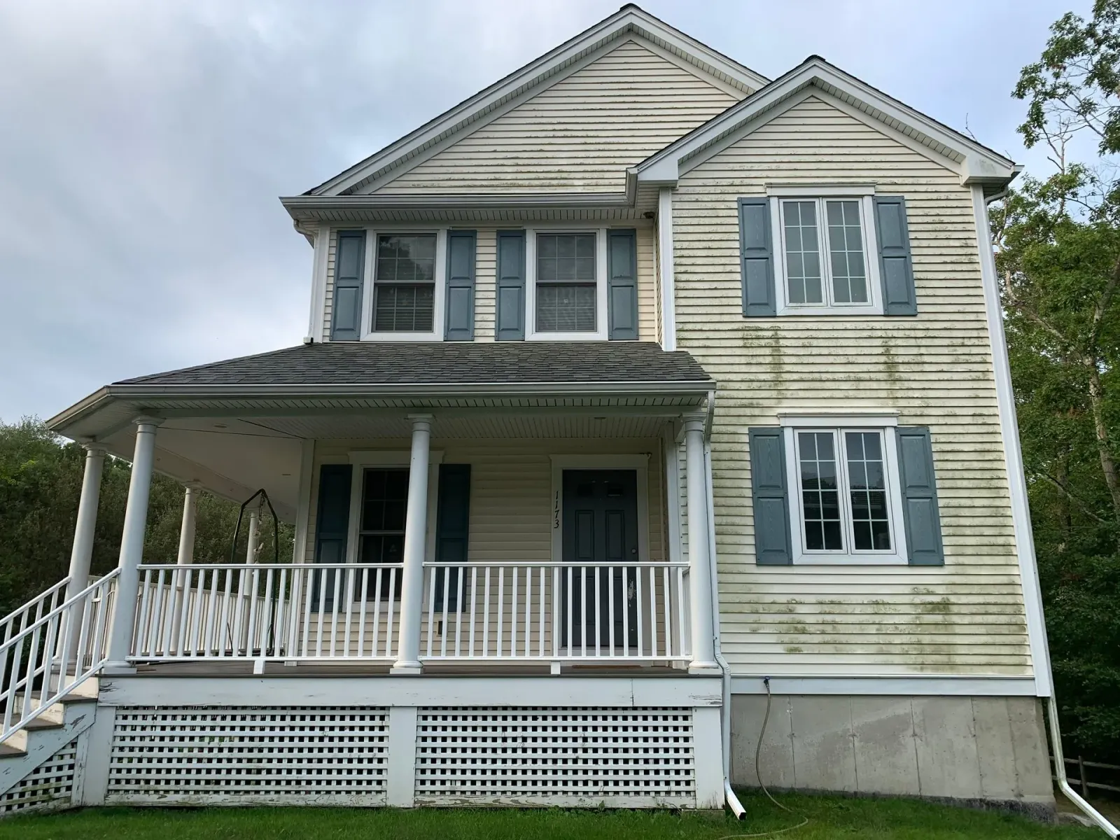 A white house with blue shutters and a porch