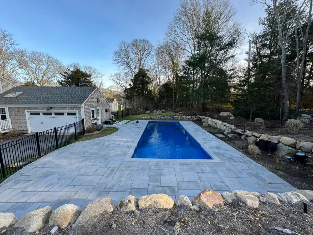Paver pool deck surrounding an in-ground pool on Cape Cod
