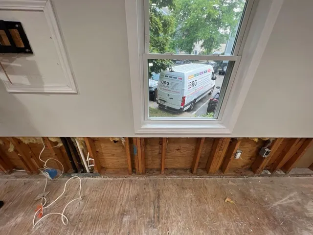 Opened lower wall beneath a window with a BRG service van visible outside