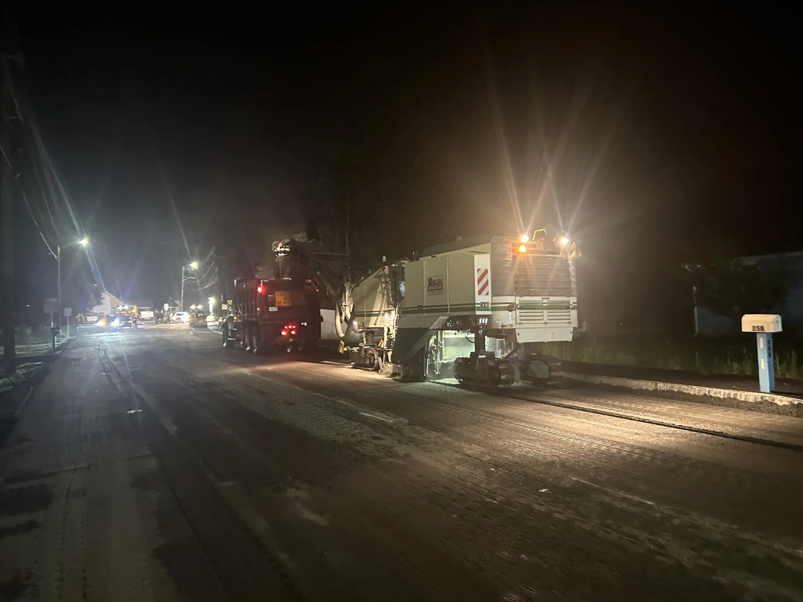 Walsh Contracting Corp performing nighttime road milling operations on an active roadway in preparation for asphalt resurfacing.