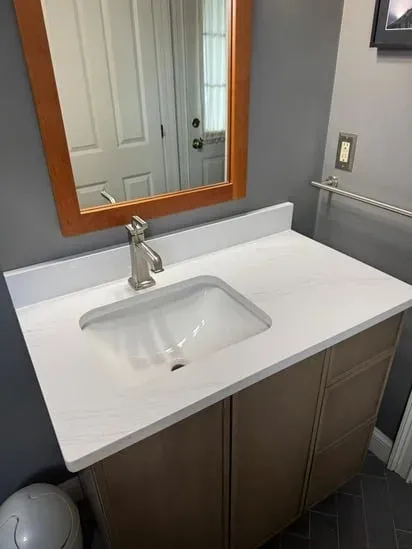 Close-up of our recently fabricated Calacatta Quartz Concord MA vanity project, highlighting the precise edge profile and matching backsplash.