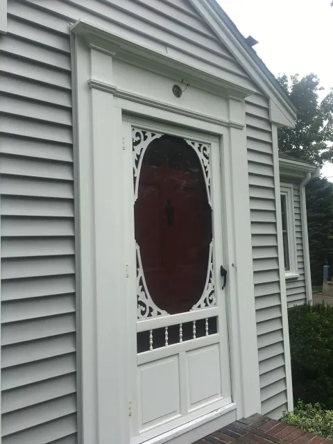 A white house with a red door and a window