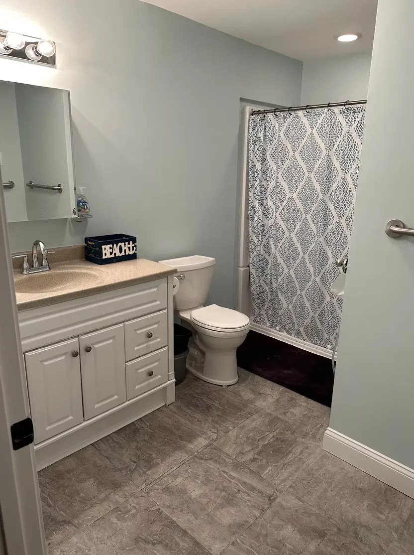 Modern bathroom renovation with white vanity and gray tile
