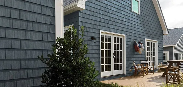 Blue house with patio and deck showing siding options for exterior appeal.