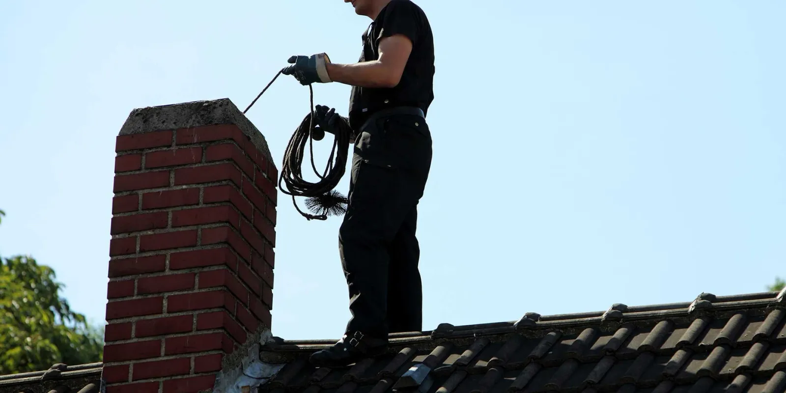 Man inspecting chimney with sweep