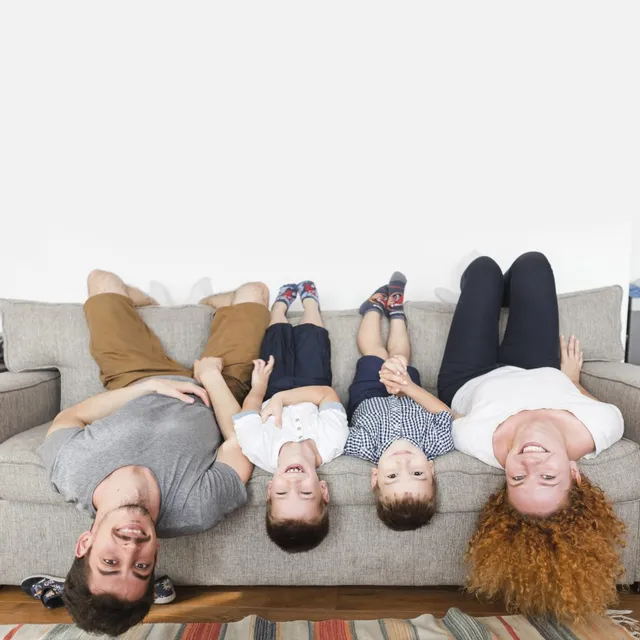 portrait-happy-family-lying-upside-down-sofa