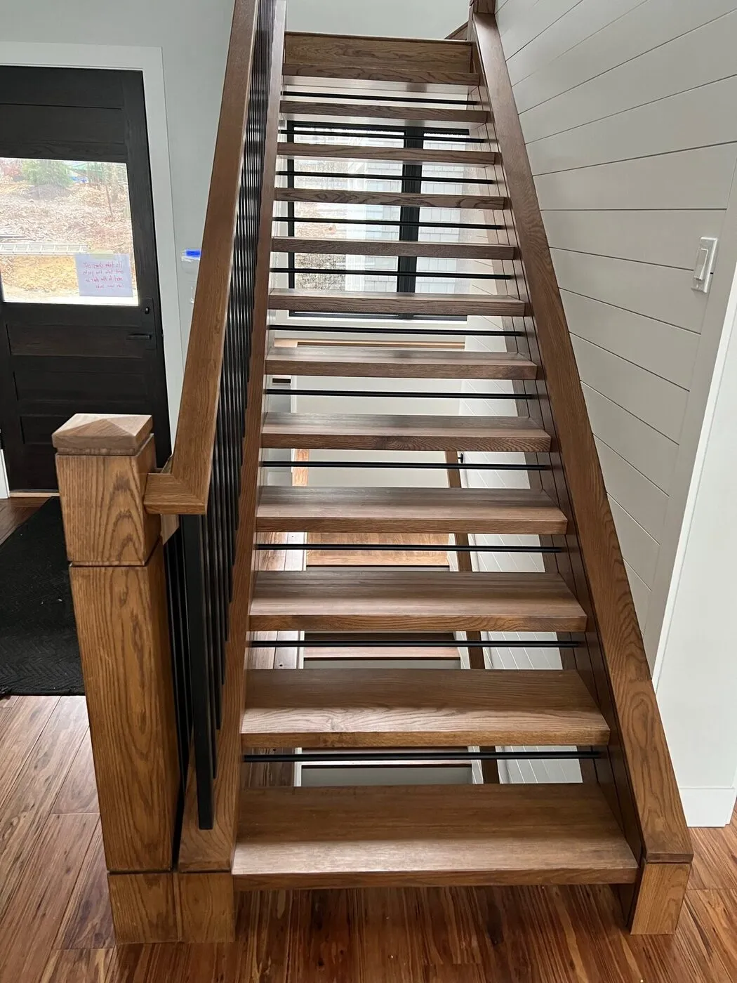 Staircase with a wood handrail, oak treads and slim metal balusters