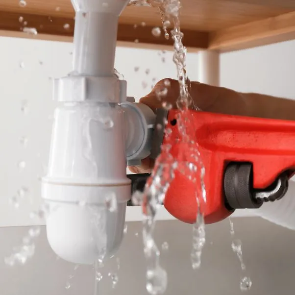 close up repairing leaking pipe on sink gray me