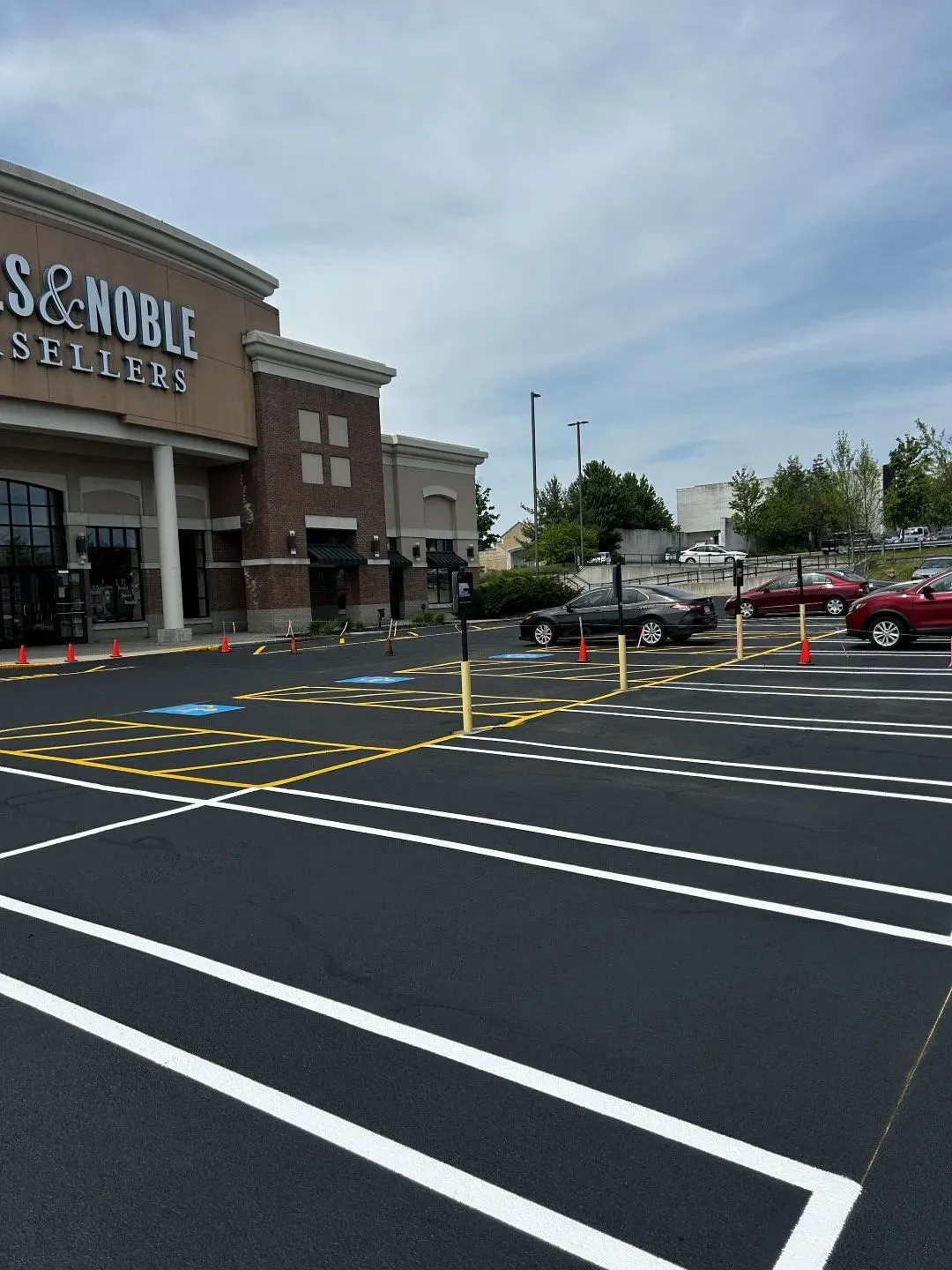 Parking lot outside a Barnes & Noble with marked accessible spaces and parked cars under a cloudy sky