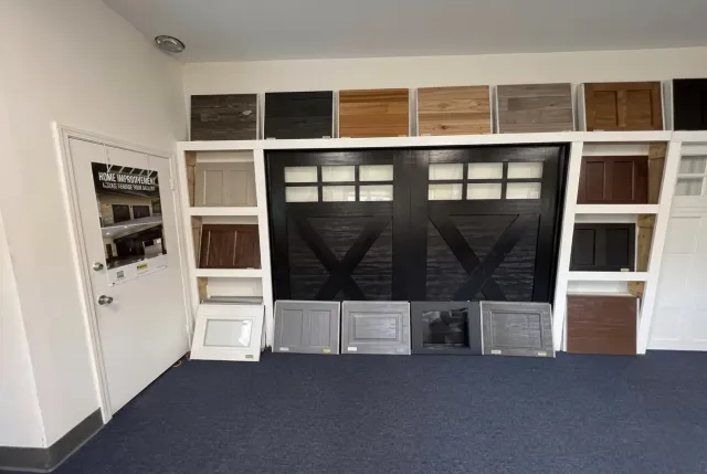 Empty room with built-in wall shelving, dark fireplace surround, and blue carpet
