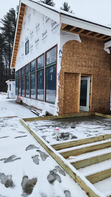 Home addition under construction with weather-tight envelope and new windows