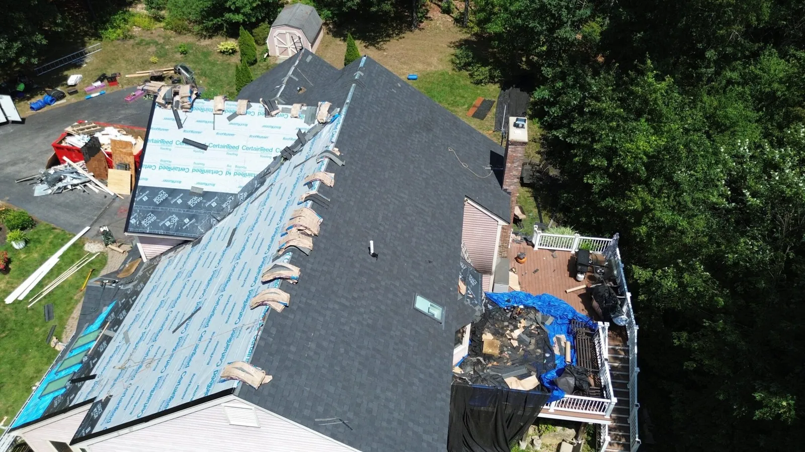 Aerial view of house roof renovation with materials laid out.