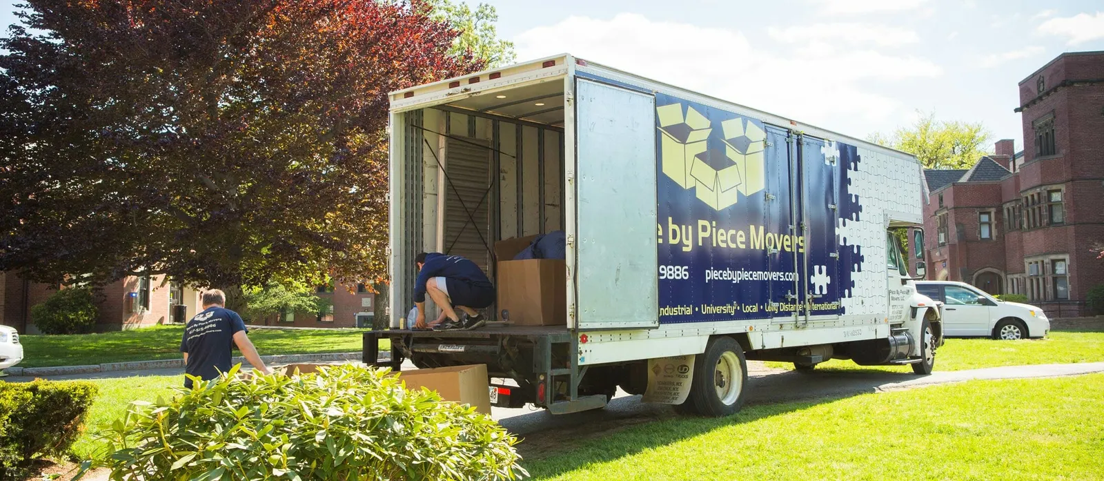 Branded Piece by Piece Movers box truck being loaded on a residential job