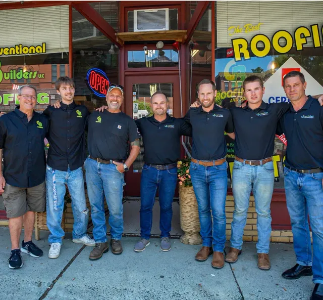 Six men in black shirts and jeans stand outside a storefront with an OPEN sign.