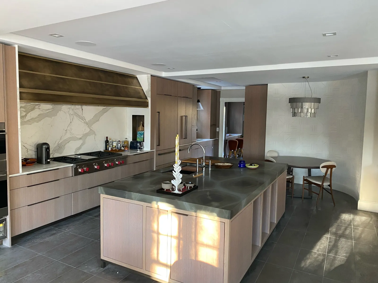 Contemporary kitchen with marble hood surround and island