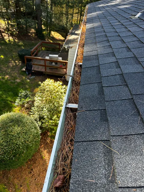 Gutter clogged with leaves and debris on a Rhode Island roof before cleaning