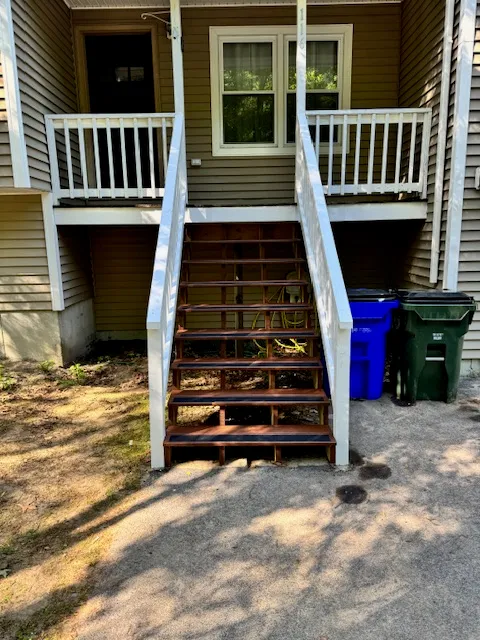 Wide view of a rebuilt stair run and repaired deck entry in Goffstown