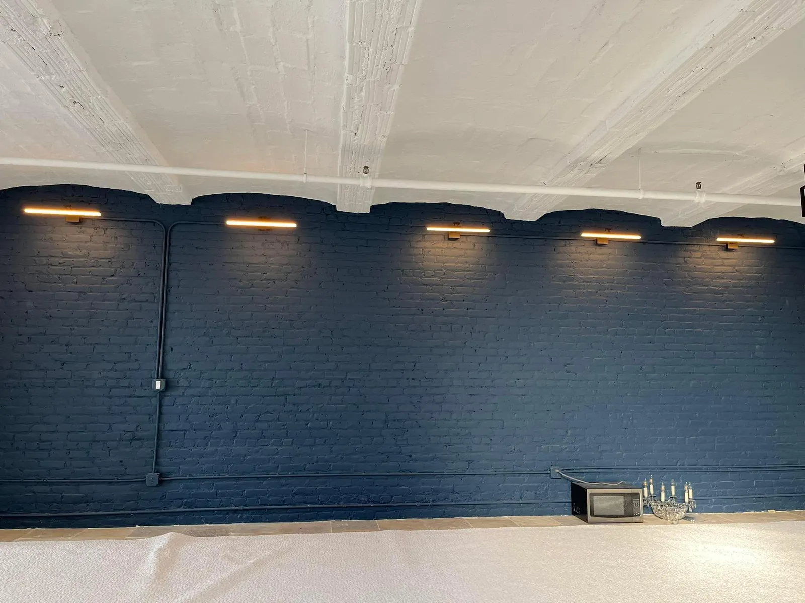 Linear wall lighting installed on a painted brick wall