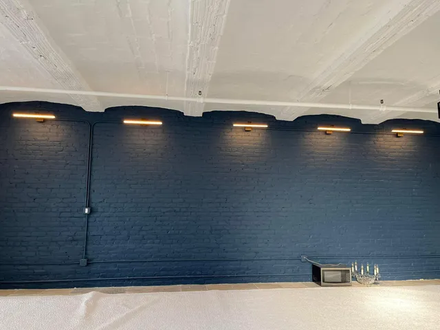 Linear wall lighting installed on a painted brick wall