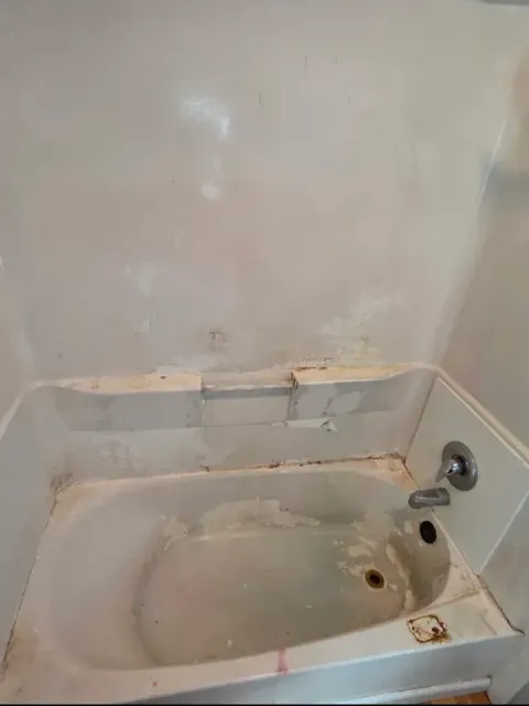 Worn damaged bathtub and surround before reglazing