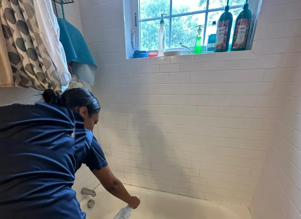 Allegry cleaner scrubbing and detailing a bathtub during a professional cleaning in Metro Boston