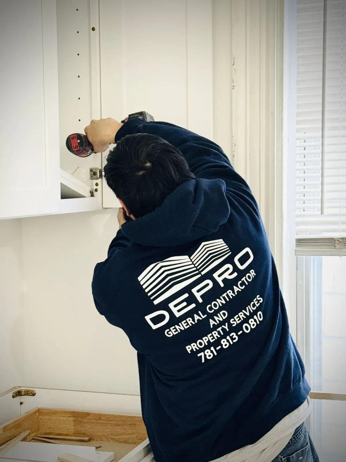 A contractor in a navy hoodie with