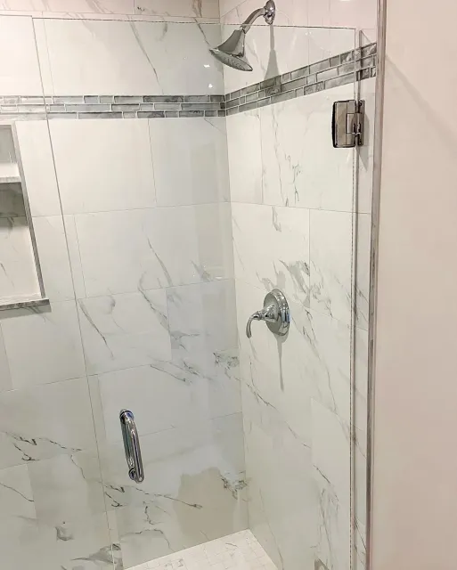 A shower stall with a glass door and a shower head.