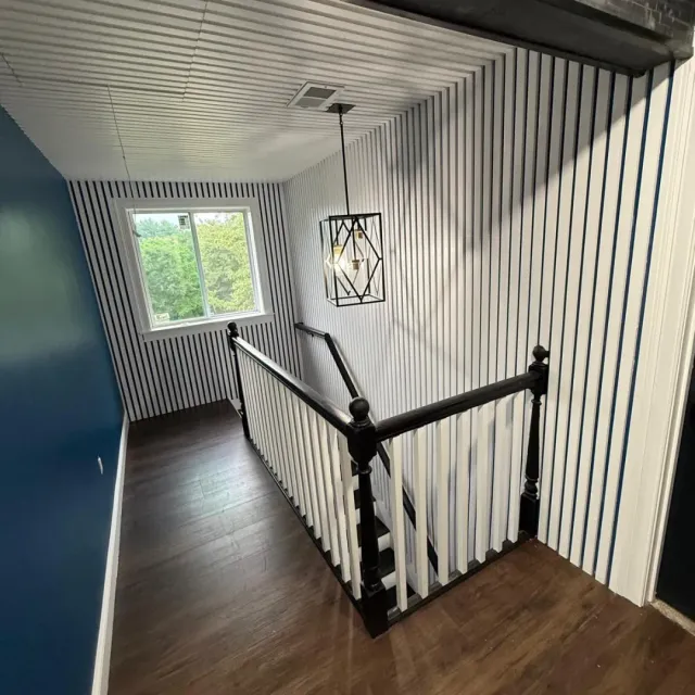 Upper stair landing with custom slat walls, chandelier and refinished hardwood in Lexington, MA — Tinbercraft
