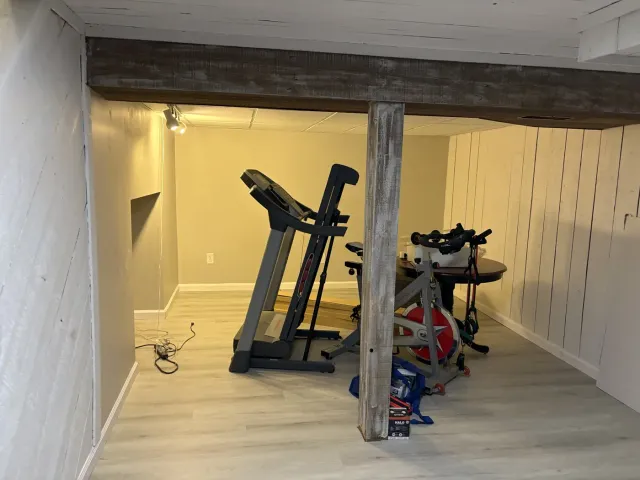 Finished basement room with new gray walls, white trim and light luxury vinyl plank flooring