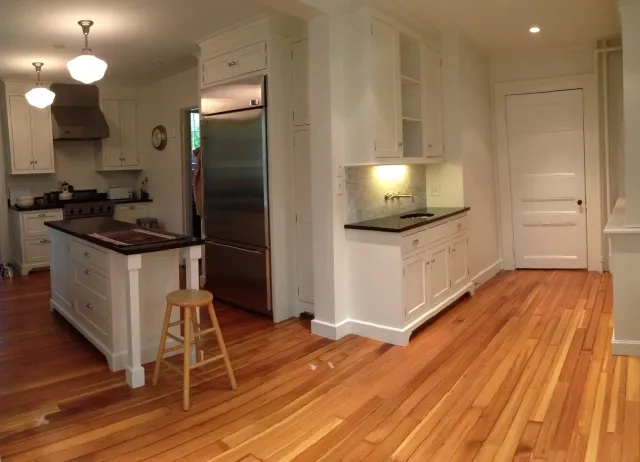 Renovated kitchen with custom cabinetry and reclaimed floor