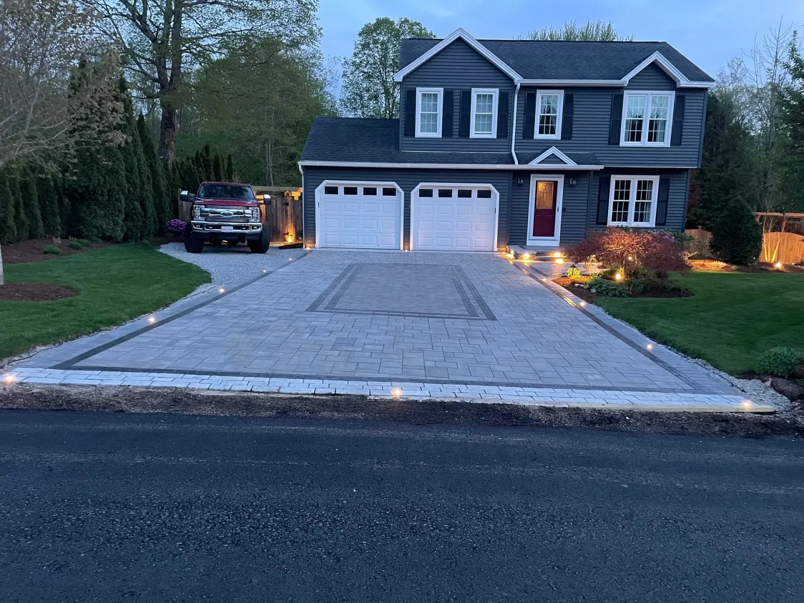 A truck is parked in front of a large house.