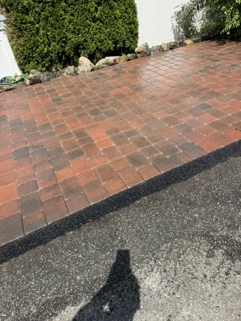 Completed brick paver edge beside asphalt