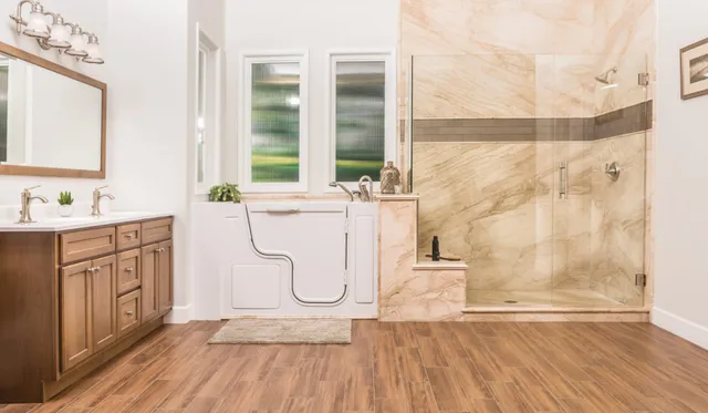 Re-Bath's French Mocha Transitional bathroom design featuring French Mocha DuraBath Natural Stone wall surround, Santa Fe walk-in tub in smooth white with brushed nickel hardware, and Bertch cabinet with brushed nickel knobs.