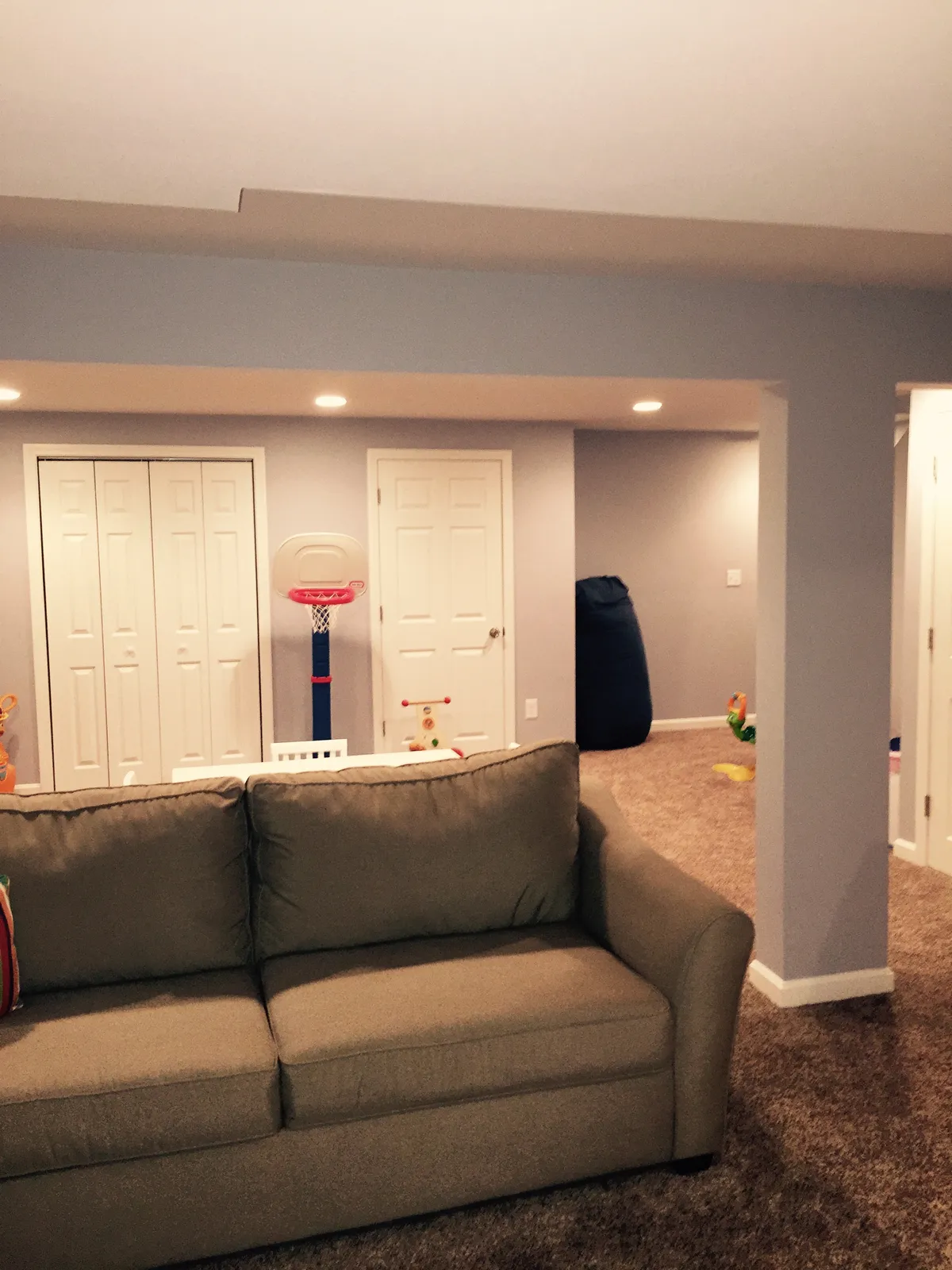 Finished basement family room with recessed lighting and carpet