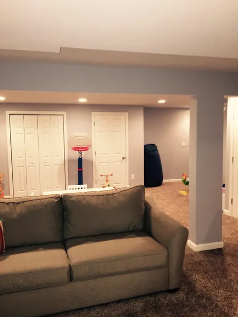 Finished basement family room with recessed lighting and carpet