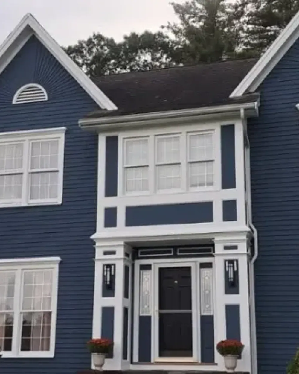 Navy New England colonial with crisp white trim, freshly painted by Milena Construction in Southern NH