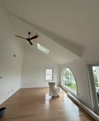 plastered room with arched window and vaulted ceiling