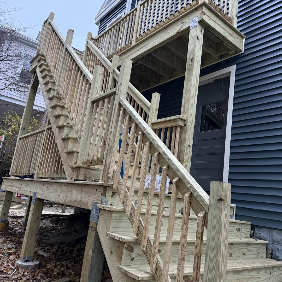 Completed pressure-treated exterior deck with custom railings in Arlington, MA — Tinbercraft Construction