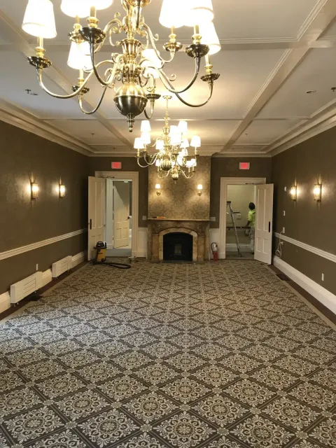 Finished event hallway with chandeliers and marble fireplace