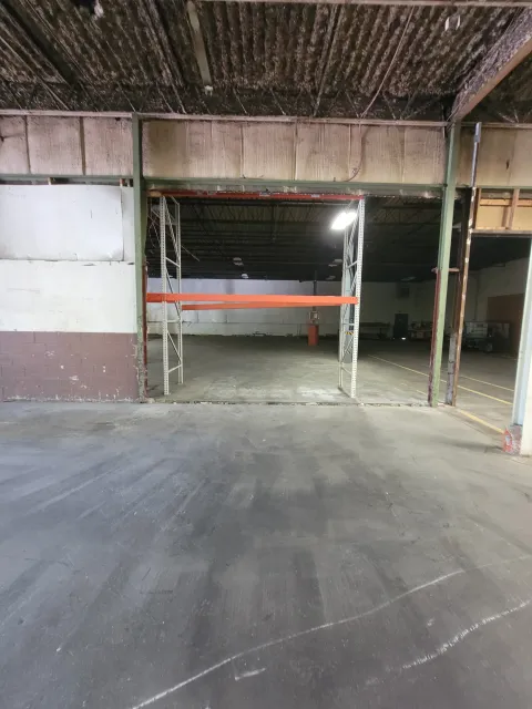 Empty parking garage with an open storage area and concrete floor and ceiling.