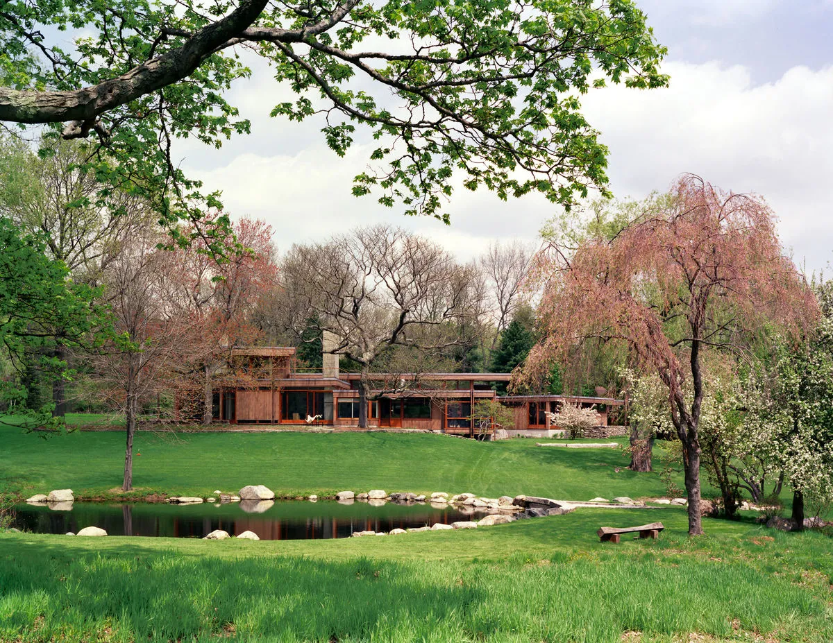 The home set in its landscape beside a pond