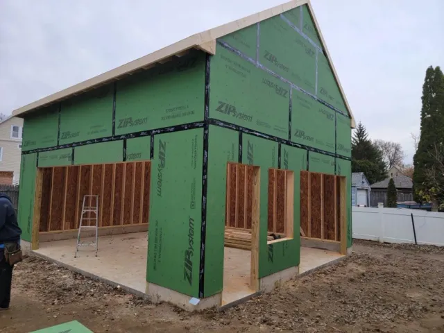 A man is standing in front of a building under construction.