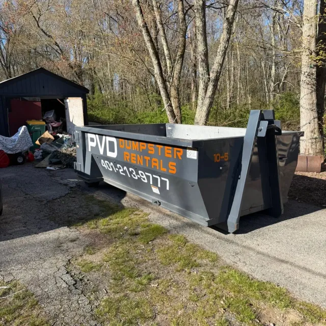 10 yard dumpster positioned at the garage door on a garage cleanout job in Rhode Island