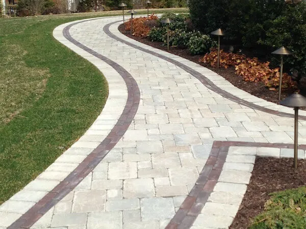 Walkway with coping surrounded by flowers and grass