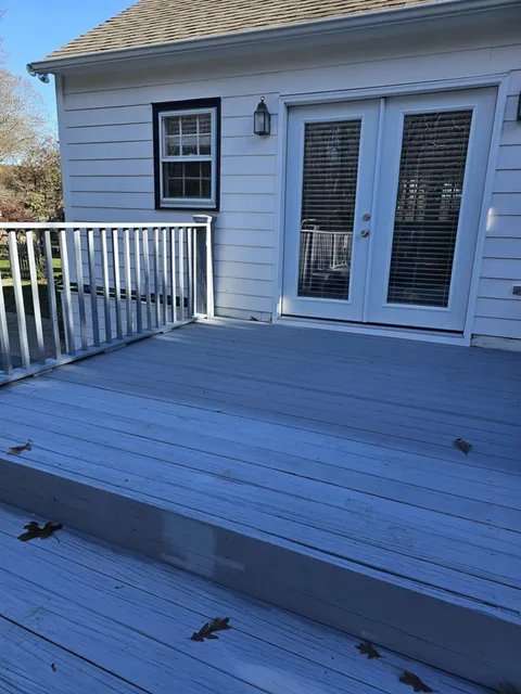 Before: backyard deck with worn gray paint and white railings