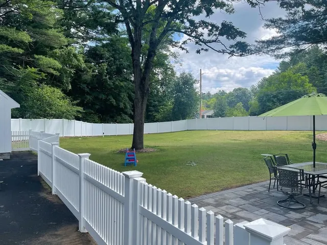 White vinyl picket fence enclosing a back yard